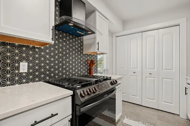 a kitchen with a stove and a white cabinet
