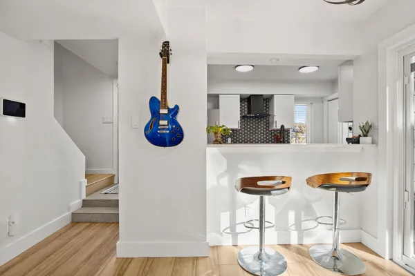 a kitchen with stainless steel appliances kitchen island granite countertop a stove a sink and a dining table with wooden floor