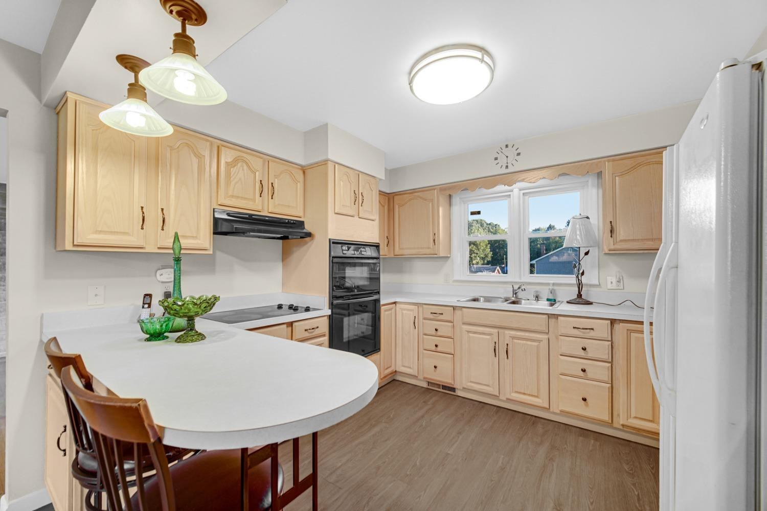 3508 Highway 20 Rolling Prairie, IN 46371 - Photo 7 of 29 a kitchen with stainless steel appliances chandelier cabinets and wooden floor