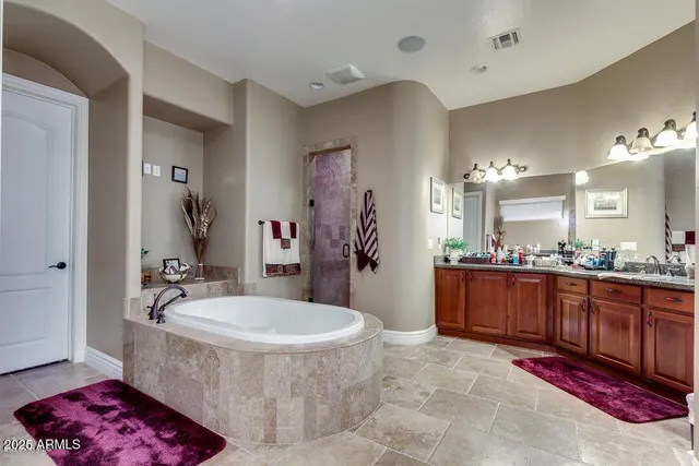 a bathroom with a tub sink and mirror