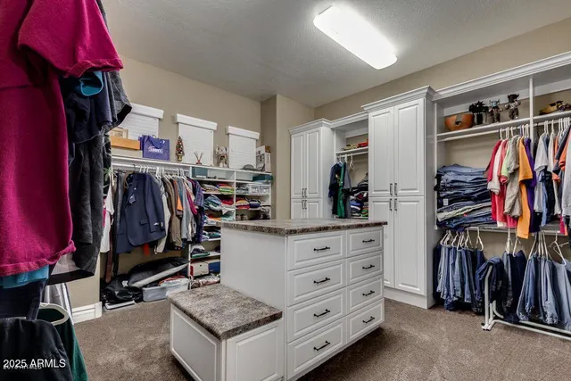 a view of walk in closet with clothes and shoes