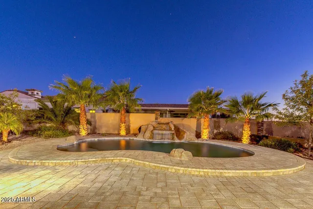a view of a swimming pool with a lawn chairs and potted plants