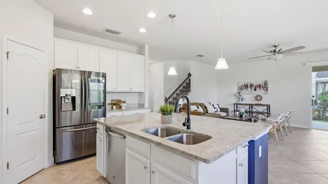 a kitchen with stainless steel appliances kitchen island a refrigerator and a sink
