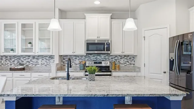 a kitchen with stainless steel appliances granite countertop a sink and a refrigerator