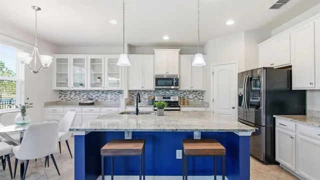 a kitchen with stainless steel appliances granite countertop a sink refrigerator and microwave