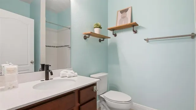 a bathroom with a sink a toilet and a mirror
