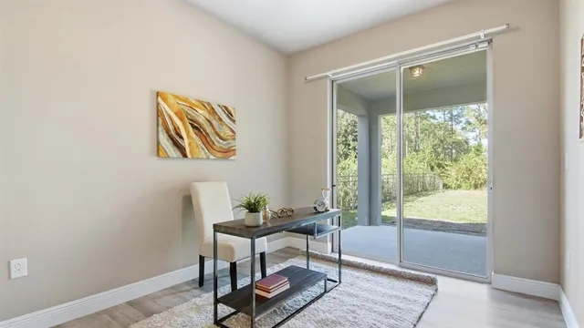 a view of a workspace with wooden floor and a window