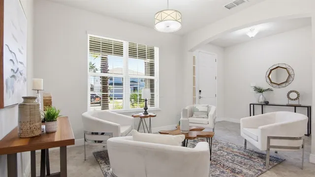a living room with furniture a table and a large window
