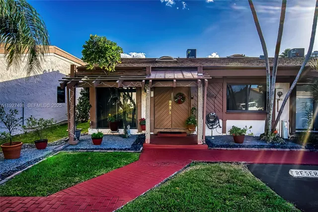 a view of a house with potted plants and a table