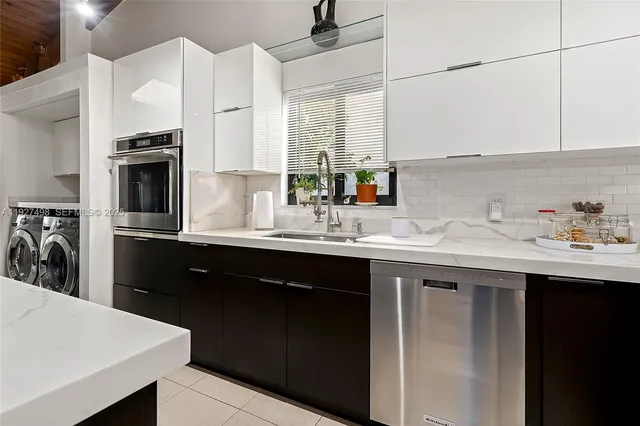 a kitchen with stainless steel appliances granite countertop a refrigerator a sink dishwasher and a stove with wooden floor