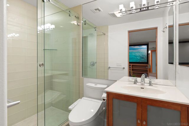 a bathroom with a sink a toilet and shower