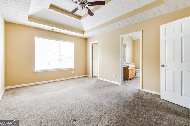 a bathroom with a granite countertop sink a toilet and a window