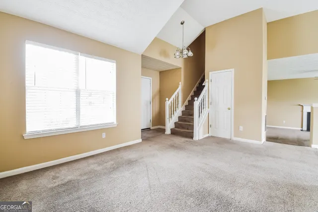 a view of an empty room with a fireplace and a window