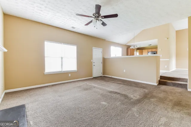 a kitchen with stainless steel appliances granite countertop a stove top oven a sink a counter top space cabinets and a window