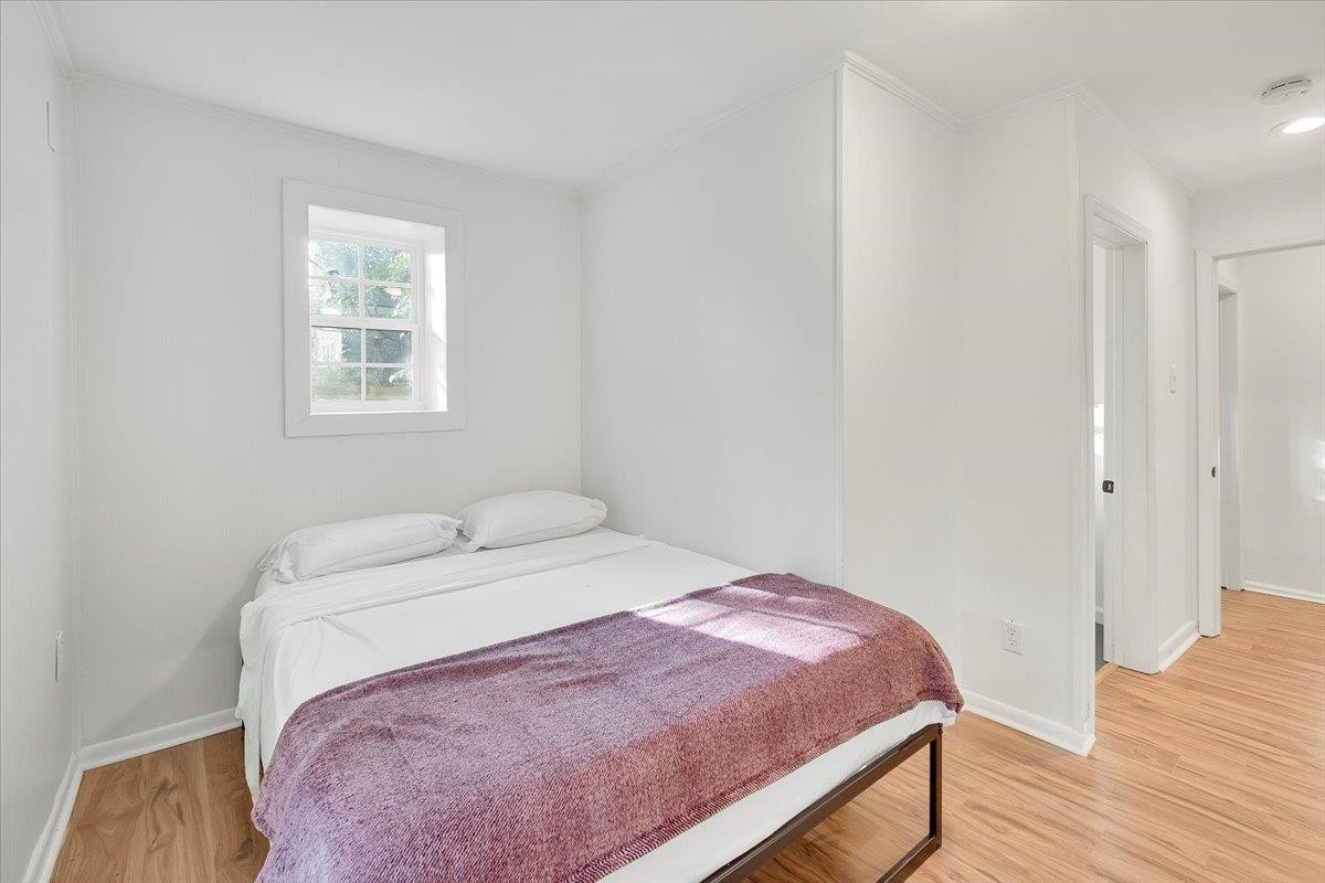 211 North State Street Raleigh, NC 27601 - Photo 21 of 50 a bedroom with a bed and wooden floor