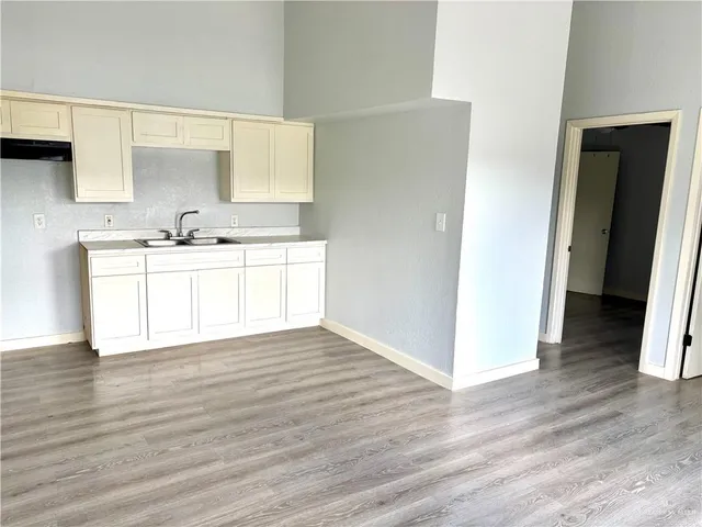 a view of a kitchen with wooden floor and a sink