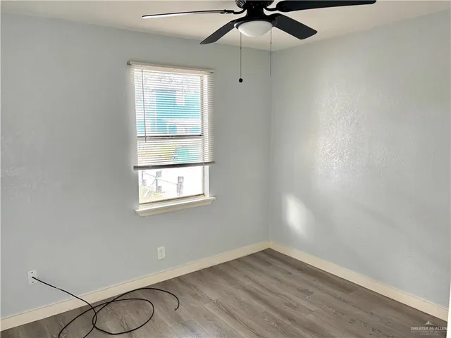 an empty room with a window and a fan