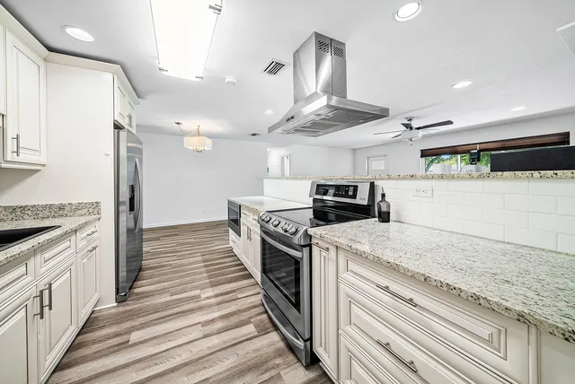 a kitchen with granite countertop a stove and a sink