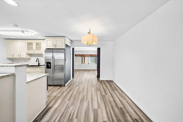 a kitchen with a refrigerator and wooden floor