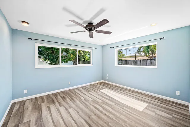 a view of a bedroom with wooden floor and windows