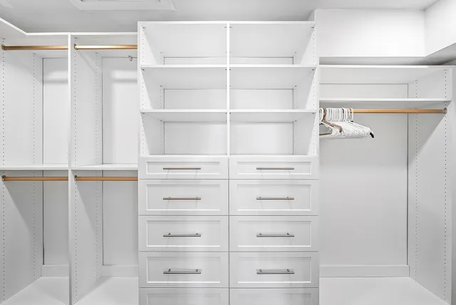 a view of walk in closet with empty racks