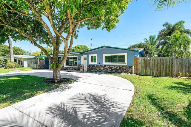 a front view of a house with a yard and tree