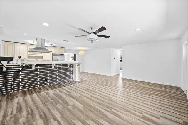 a view of a room with wooden floor and a ceiling fan