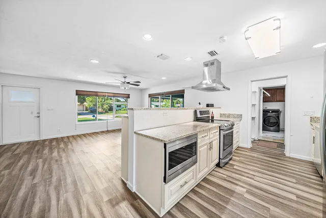 a kitchen with stove and wooden floor