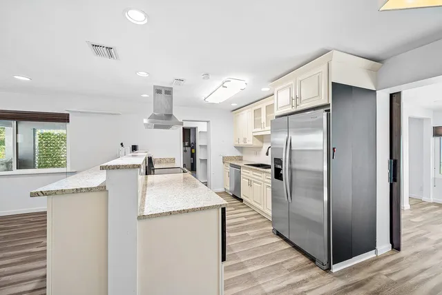 a kitchen with granite countertop a refrigerator and a sink
