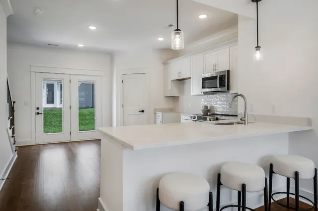 a kitchen with kitchen island white cabinets and stainless steel appliances