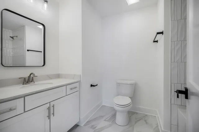 a bathroom with a toilet a sink and mirror