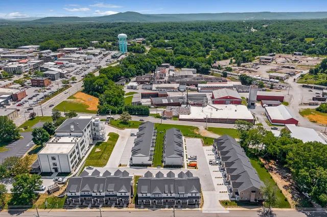 an aerial view of residential houses with outdoor space and swimming pool