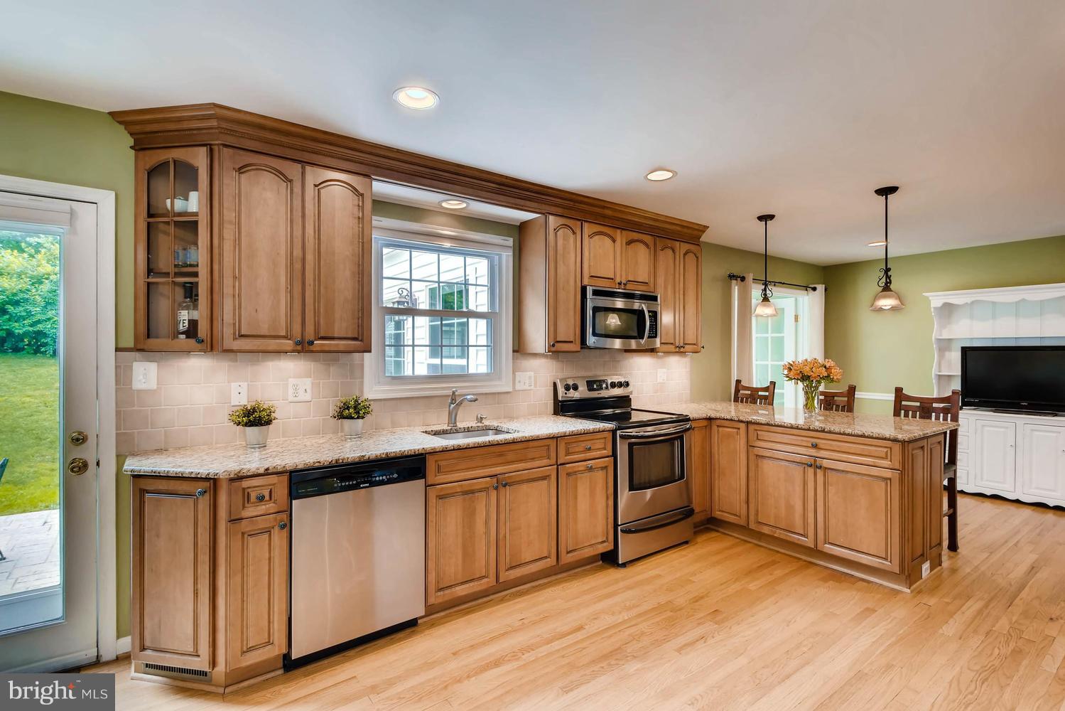 10510 Longbranch Road Cockeysville, MD 21030 - Photo 4 of 28 a kitchen with stainless steel appliances granite countertop wooden cabinets a sink a stove a dining table and chairs