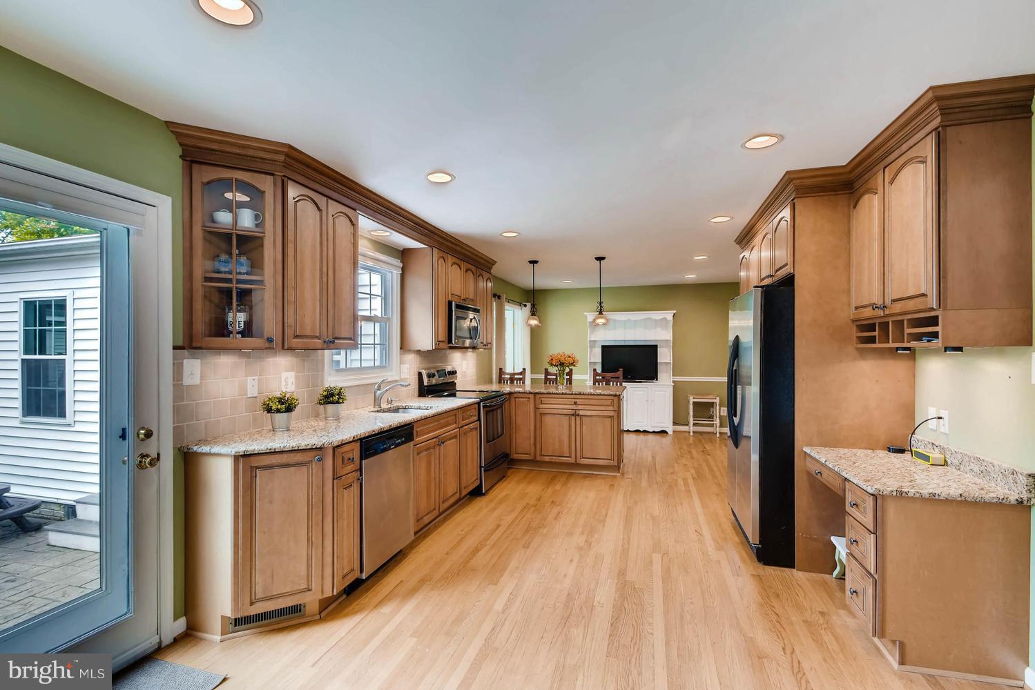 10510 Longbranch Road Cockeysville, MD 21030 - Photo 5 of 28 a large kitchen with stainless steel appliances a large counter top a stove a chimney a sink and cabinets