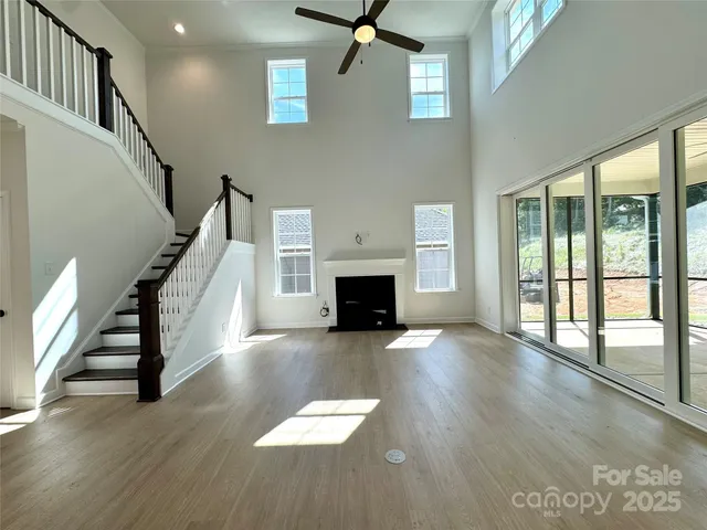 a view of a livingroom with wooden floor and a fireplace