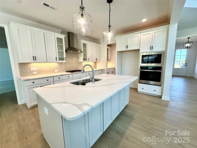 a kitchen with kitchen island a sink stainless steel appliances and cabinets