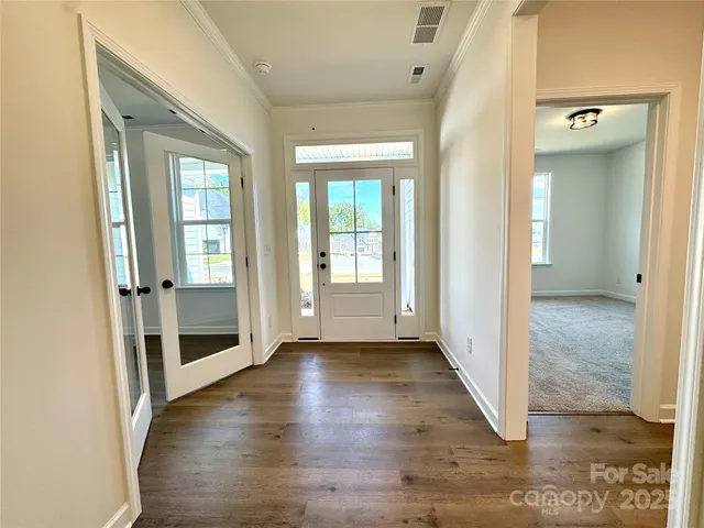 a view of a hallway with wooden floor and stairs