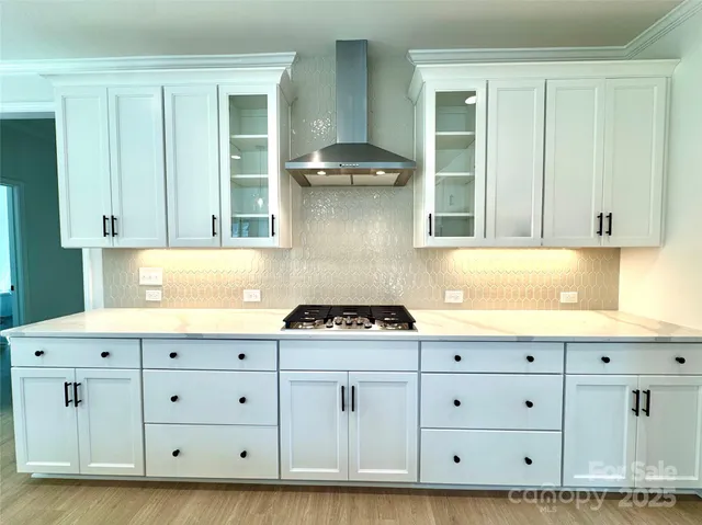 a kitchen with white cabinets and a stove