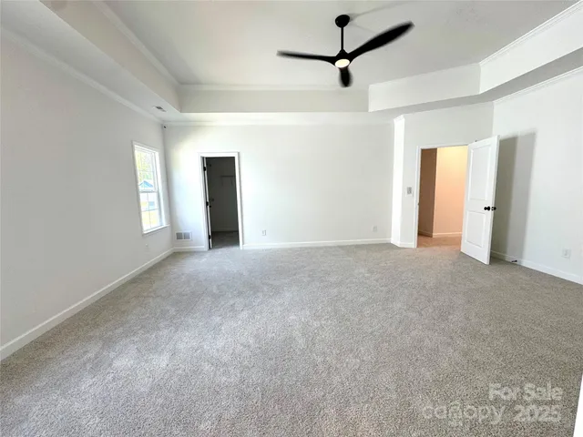 a view of a big room with windows and ceiling fan