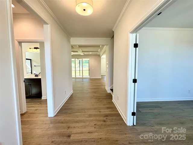 a view of a hallway with wooden floor and a living room