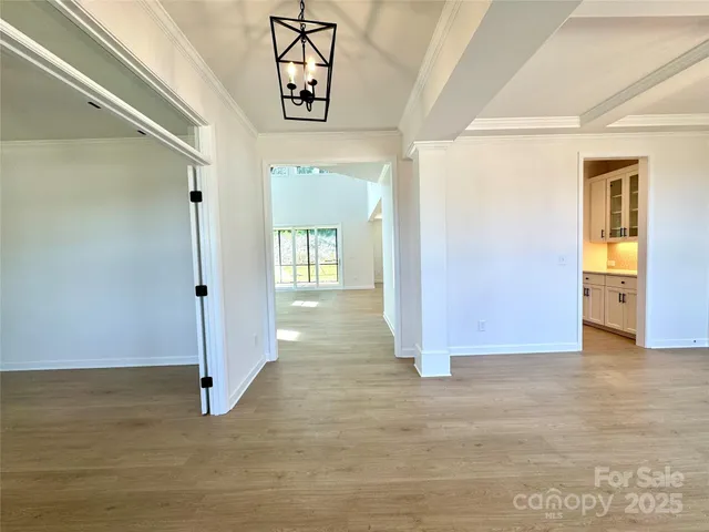 a view of a hallway with wooden floor and closet