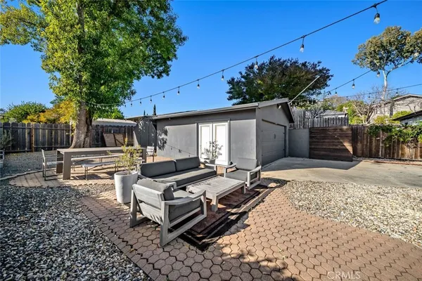 a backyard of a house with barbeque oven table and chairs