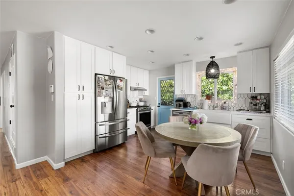a kitchen with stainless steel appliances a dining table and chairs