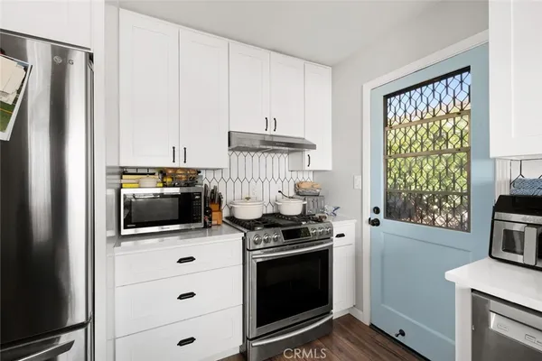 a kitchen with stainless steel appliances a stove a microwave and a refrigerator
