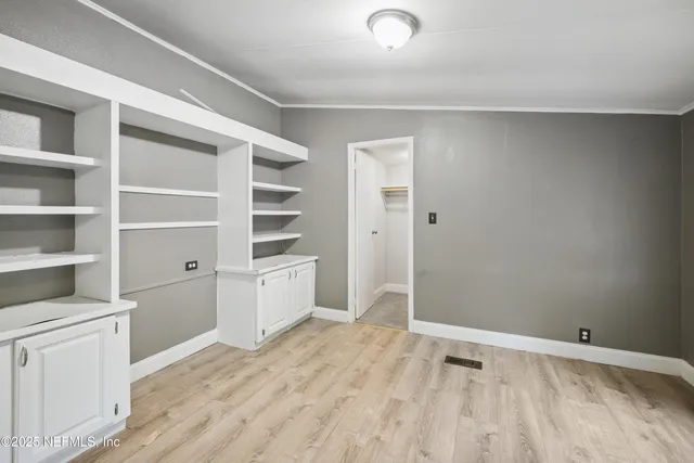 a kitchen with a refrigerator and white cabinets