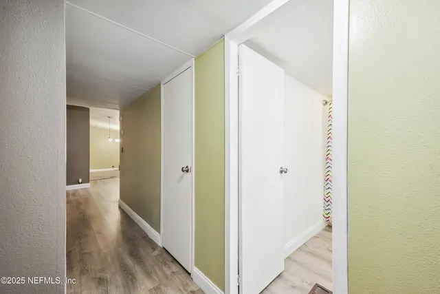 a view of a hallway with wooden floor