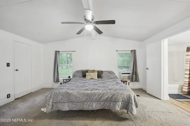 a bedroom with a large bed and a window