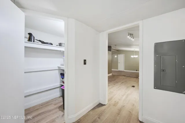 a bathroom with a walk in closet and wooden floor