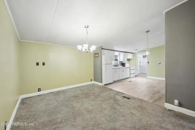 a view of a big room with windows and chandelier fan