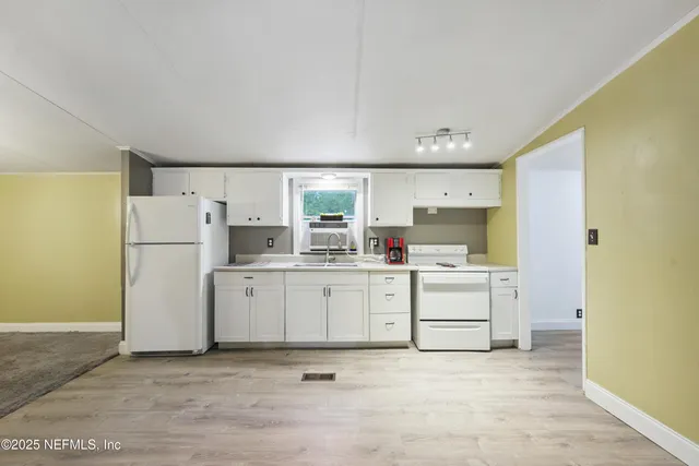 a kitchen with white cabinets and white appliances